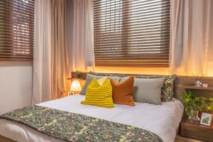 a bed with colorful pillows in a room with windows at 행궁주택 in Samgong