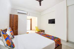 a bedroom with a white bed and a tv at FabHotel Destiny Living in Pune