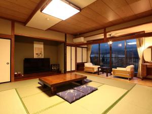 a living room with a table and a television at Hotel B FUJI-YAMANAKAKO in Yamanakako