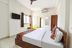a bedroom with a large bed and a tv at FabHotel Destiny Living in Pune +24 photos