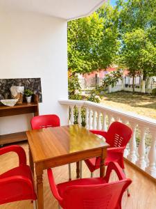 a dining room with a wooden table and red chairs at Hotel Bar Restaurant MANI in Velipojë