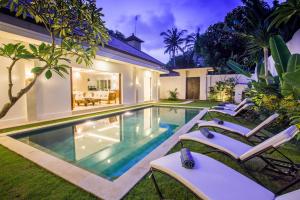 a swimming pool in the backyard of a house at Villa Kamboja Deluxe in Seminyak