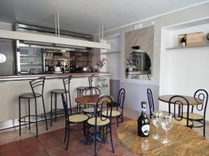 eine Küche mit einer Bar mit Stühlen und einem Tisch in der Unterkunft Hotel Del Mera in Sorico