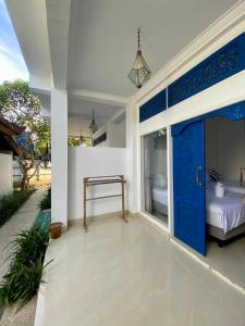 a bedroom with a bed and a blue door at Inti Bungalows in Gili Trawangan
