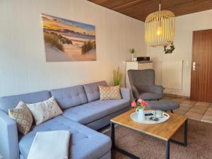 a living room with a blue couch and a table at Nr 64 - Ferienhaus Krabbe 12 in Carolinensiel +25 photos