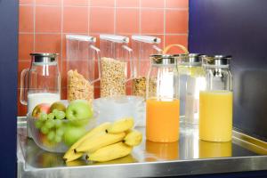 a counter with fruit and two bottles of orange juice at Hotel Profis in Diepoldsau