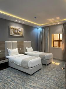 a hotel room with two beds and a couch at Qimam Park Abha 2 in Abha +22 photos