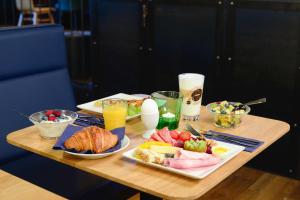 a wooden table with breakfast foods and drinks on it at Hotel Profis in Diepoldsau