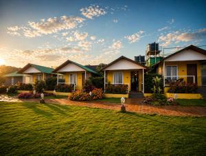 a house with a lawn in front of it at Red Button Resort & Go-Karting in Mahabaleshwar