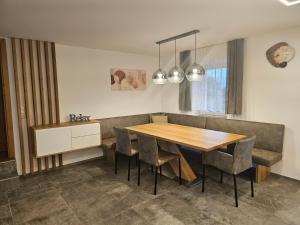 a dining room with a wooden table and chairs at Ferienwohnung Scheuringer in Enzenkirchen