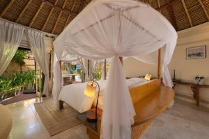 a bedroom with a bed with a canopy at Banyan Tree Vabbinfaru in Male City
