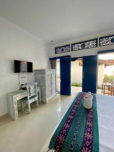 a living room with a bed and a television at Inti Bungalows in Gili Trawangan