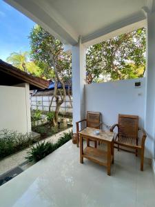 two chairs and a wooden table on a porch at Inti Bungalows in Gili Trawangan