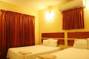 ein Hotelzimmer mit zwei Betten und einem Fenster in der Unterkunft Hotel Alberto in Cárdenas