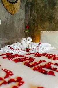 a bed with white towels and a rose on it at Puri Kurnia Ayu in Ubud +56 photos