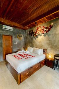 a bedroom with a bed with red roses on it at Puri Kurnia Ayu in Ubud