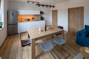 a kitchen and dining room with a wooden table and chairs at Apartmány LISON in Valtice