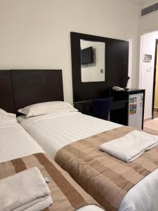 a hotel room with two beds and a desk at Miaad Al Majd Hotel in Mecca +16 photos