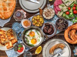 a table topped with plates of food with breakfast foods at Dreamy luxury two-bedroom penthouse apartment with special forest, mountain and sea views in Alanya