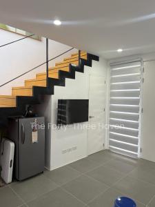 a living room with a staircase and a refrigerator at The Forty-Three Haven in Calo
