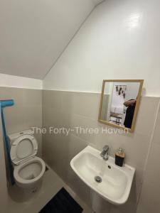 a bathroom with a white toilet and a sink at The Forty-Three Haven in Calo