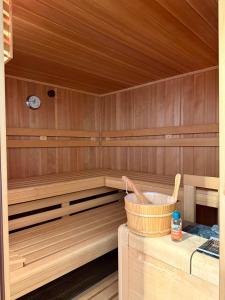 a sauna with a tub and a bucket in it at Landhaus Wulfenia - APARTMENT KLAGENFURT - Private Sauna, Smart-TV, Air Conditioning, Free Parking in Klagenfurt