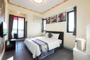 um quarto com uma cama e algumas janelas em Melinda Resort em Hengchun Old Town