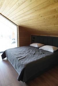 a large bed in a room with a wooden ceiling at Turanga hotel in Saty