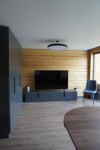 a living room with a large television and a blue chair at Turanga hotel in Saty