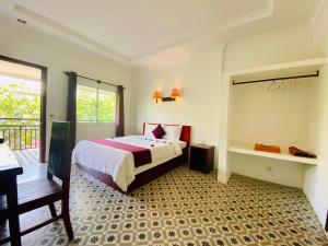 a bedroom with a bed and a desk in it at STC Hotel School in Phumĭ Réach Born (1)