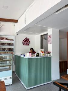 a woman sitting at a counter in a restaurant at The Berry House in Satara