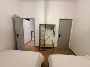 two beds in a room with two doors at Urban Loft Dakar by Immo Kit BNB in Dakar