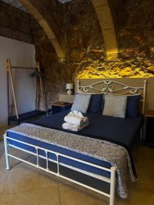 a bedroom with a bed with blue sheets and pillows at Ta' Tereża Farmhouse in Xagħra +9 photos
