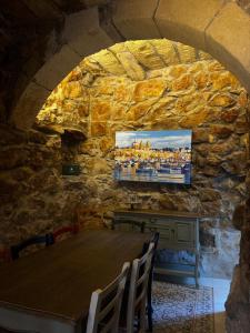 a dining room with a table in a stone wall at Ta' Tereża Farmhouse in Xagħra