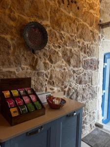 a counter with a box of food on a stone wall at Ta' Tereża Farmhouse in Xagħra