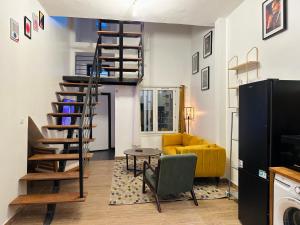 a spiral staircase in a living room with a yellow couch at Urban Loft Dakar by Immo Kit BNB in Dakar