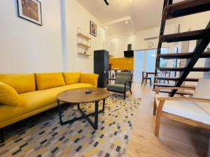 a living room with a yellow couch and a table at Urban Loft Dakar by Immo Kit BNB in Dakar