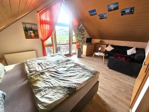a large bed in a room with a large window at Haus Herdi-Schön in Herdwangen-Schönach