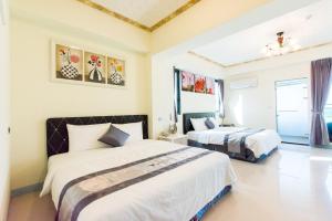 um quarto com 2 camas e uma janela em Melinda Resort em Hengchun Old Town