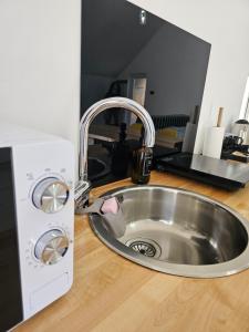 a kitchen counter with a sink and a microwave at Studio M in Năsăud +20 photos