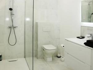 a white bathroom with a shower and a toilet at Suite des Princes with Private Garden by La Boîte En Plus in Chantilly