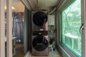a washing machine in a room next to a window at 스테이 한집 in Suwon