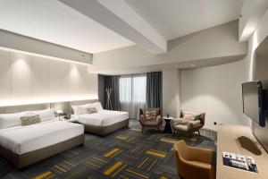 a hotel room with two beds and a tv at RELC International Hotel in Singapore +30 photos