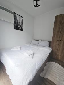ein großes weißes Bett mit weißen Laken und Kissen in der Unterkunft Peak View Tiny House - Piatra Craiului Nest in Zărneşti