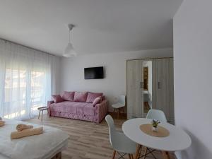 a living room with a pink couch and a table at RIO Residence in Soko Banja