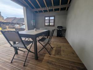 a dining room with a table and chairs on a deck at Gîte du joliment in Consigny