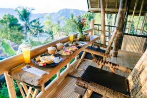 a table with plates of food on a balcony at Ayo Hill Villa By Samhita Bali in Silebeng