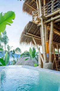 a resort with a swimming pool in front of a building at Ayo Hill Villa By Samhita Bali in Silebeng