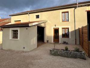 a house with a garage and a building at Gîte du joliment in Consigny