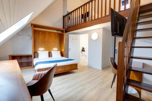 a bedroom with a king sized bed and a staircase at Karaez Hôtel - BritHotel Carhaix in Carhaix-Plouguer +77 photos
